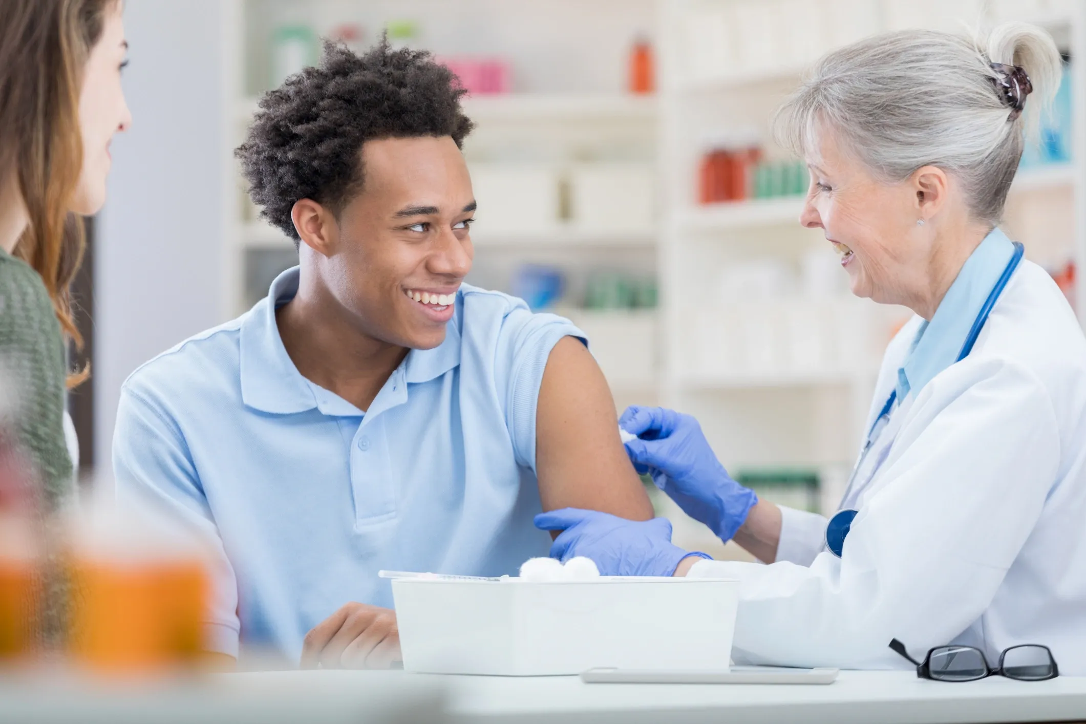 Young man receiving a vaccine from a pharmacist
